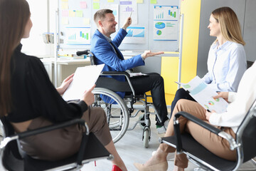 Man mentor in wheelchair conducts business seminar