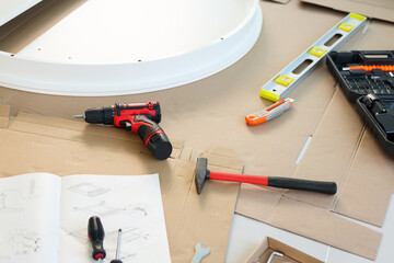 Cordless screwdriver and tool on cardboard paper assembly furniture concept