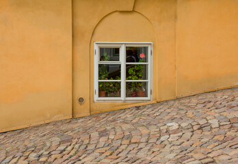 The window of the old house in front of the sidewalk.