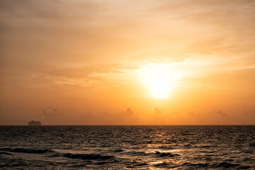 sunrise in ocean or sea water with silhouette of ship on sunset sky background, nature