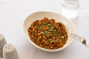 lentils with vegetables in a plate on the dining table. comfort homemade food, vegetarian lentils