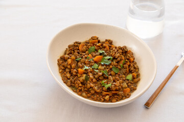 lentils with vegetables in a plate on the dining table. comfort homemade food, vegetarian lentils
