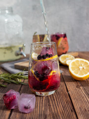 Summer drink with lemon and berries on a wooden background