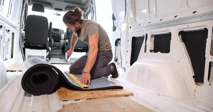 Man cutting foam insulation in the back of a van