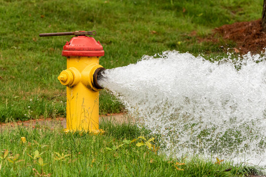 An suburban fire hydrant that has been opened letting water freely flow.