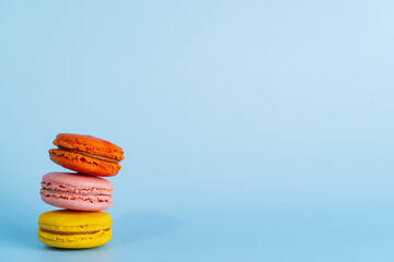 Macaron or macaroon cake sweets and colorful french desserts is vintage color or pastel color isolated on blue background and free space to place the text something. Close up and Macro photography.