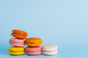 Macaron or macaroon cake sweets and colorful french desserts is vintage color or pastel color isolated on blue background and free space to place the text something. Close up and Macro photography.