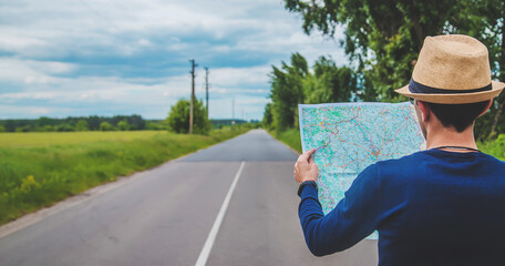 A man looks at a map on the road. Selective focus.