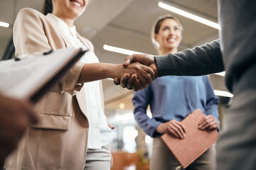 Close-up of business partners shaking hands after successful meeting in the office. - obrazy, fototapety, plakaty