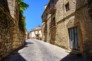 Ancient facades of old stone houses in sunny day and blue sky.