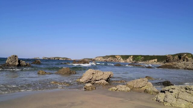 Waves breaking on the beach and on the rocks. Pe&ntilde;arronda beach, Cambrian Sea.