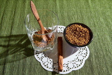Loose instant coffee in blue beautiful ceramic saucer, in glass and a small wooden spoon. A resource for making a delicious coffee drink