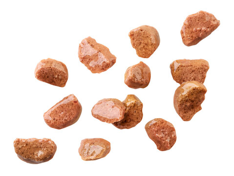 Cat food pieces of meat are flying on a white, isolated