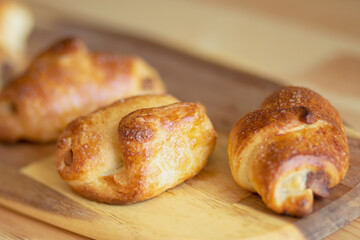 croissant, homemade fresh baked goods lies on a beautiful bamboo board on a wooden table