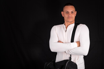 a young handsome man in a white sweatshirt with a black sports bag