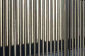 Fence texture. Close-up shot of a ribbed metal structure. Metal fence.