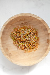 Micrograin of wheat in a wooden bowl top view on stone gray table..