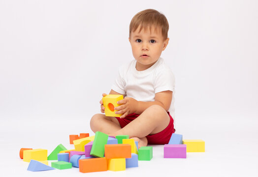 cheerful kid boy with construction set over white background