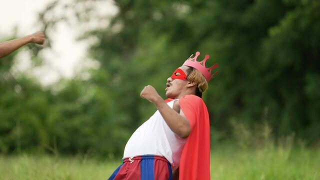 Hero man in red with crown and red mask standing and punching air