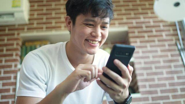 slow motion scene young man holding smartphone to chat message with online people in dating website application to make appointments to flirting for lifestyle people concept	