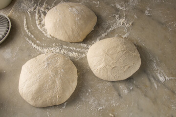 three pieces of pizza dough ready for preparation