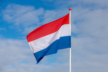 Fototapeta na wymiar National flag of the Netherlands with horizontal tricolour of red, white and blue, Dutch flag waving on the air in a sunny day as background.