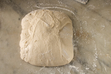 italian pizza dough with flour on grey marble