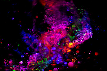 Colored water texture. Splashes of water lit in different colors.