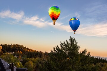 balloons fly beautifully into the sky, above the mountainous landscape