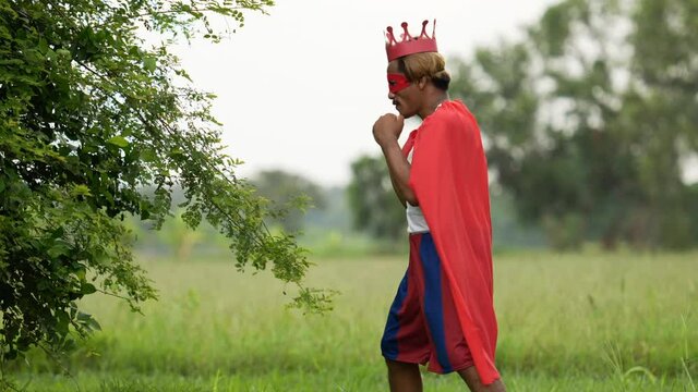 Hero man in red with crown and red mask standing and punching air