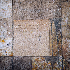 square cut stone wall closeup, natural material rough background