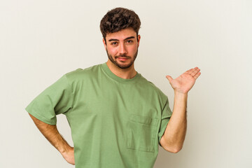 Young caucasian man isolated on white background doubting and shrugging shoulders in questioning...