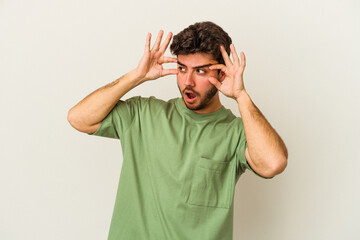 Young caucasian man isolated on white background keeping eyes opened to find a success opportunity.