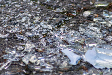 Sharp shards of a broken glass bottle on the ground with sharp blades are dangerous from vandalism and drunk people showing fragile bottle and smashed beverage crushed as weapon recycling waste