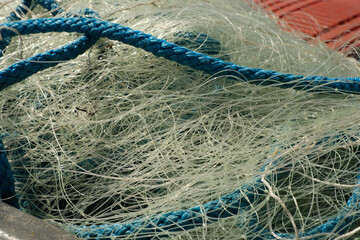 A pile of fishing rope and nylon netting. Close up view filling the frame.