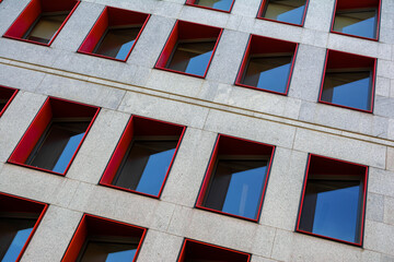 Abstract fragment of modern building facade with red window frames