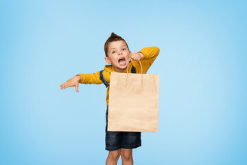 Little cute kid boy holding craft package isolated on background.
