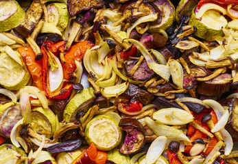 Baked vegetable background, zucchini, eggplant, sweet peppers, onions, mushrooms, black carrots