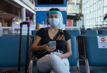 Covid-19 and social distancing. Traveling during pandemic. Young woman wearing a protective mask,...
