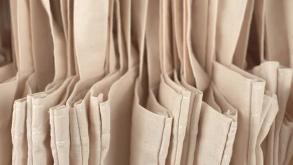 Panning footage of many beige eco bags background
