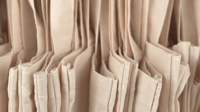 Panning footage of many beige eco bags background