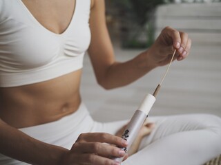 
young woman is engaged online at home on a computer. Online workouts, yoga, stretching and incense