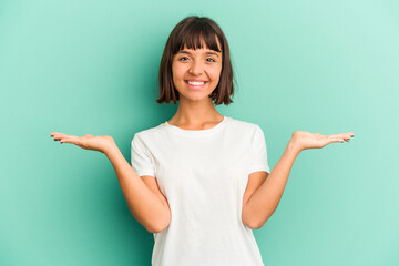 Young mixed race woman isolated on blue background showing okay sign over eyes