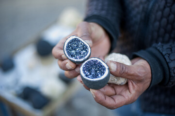local man shows a cross-section of a agate stone with crystal inside with quartzite crystals