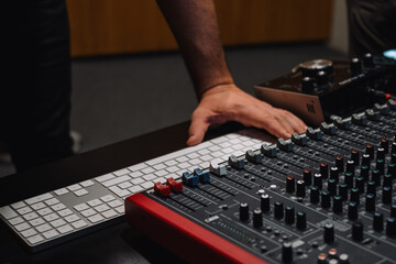 Producer hands at the keyboard in a studio. Musician arranging and mixing music in home studio....