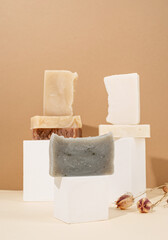 tower stack of different handmade soaps and leaves on cream background