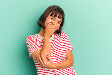 Young mixed race woman isolated on blue background smiling and pointing aside, showing something at blank space.