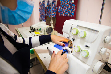 Woman hands with fabric at sewing machine