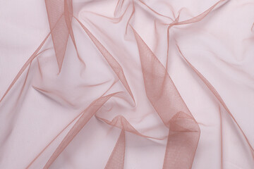 wrinkled, compressed pink tulle fabric on white background close-up