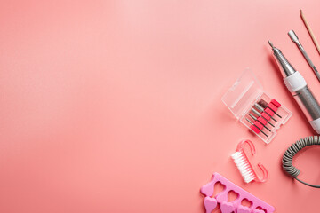 manicure and pedicure tools and other nail essentials on pink background top view. nail work flat lay concept